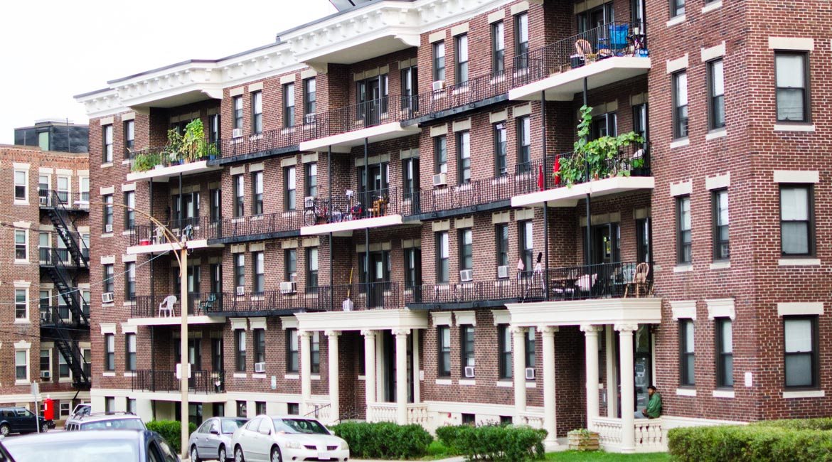 Four story brick apartment building with balconies